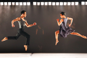 A man and a woman running through the air facing each other.